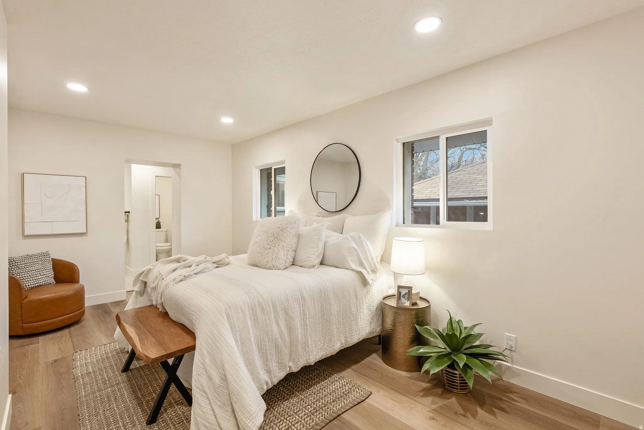 Bedroom with connected bathroom, light wood-type flooring, and recessed lighting