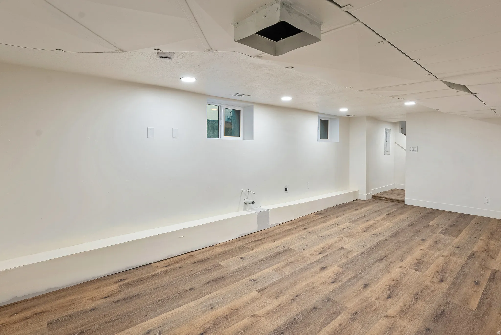 Finished basement featuring light wood-type flooring and recessed lighting