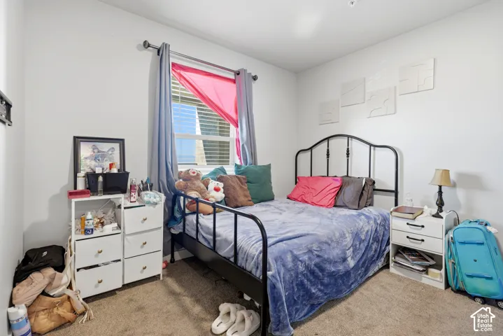 Neutral-toned interior space featuring carpeting and a window with horizontal blinds