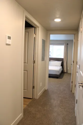 Corridor featuring dark carpet and electric panel
