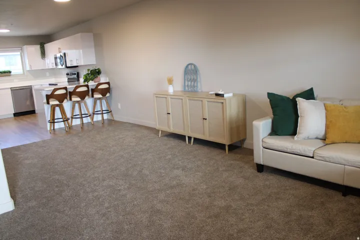 Living area with light colored carpet and baseboards