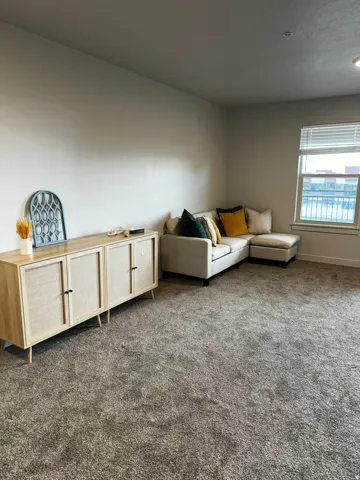 Living room featuring dark colored carpet and baseboards