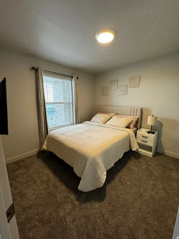 Bedroom featuring a textured ceiling and carpet flooring