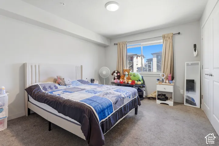 Neutral-toned room featuring wall-to-wall carpeting, a horizontal window with a metal rod, and a multi-panel door