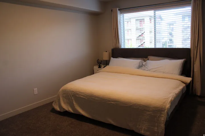 Bedroom with baseboards and dark carpet