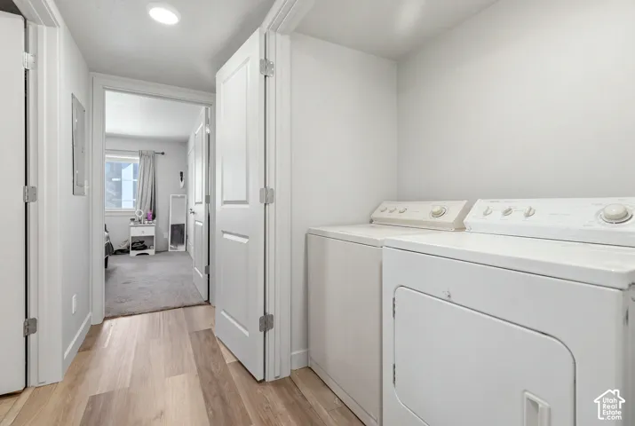 Laundry area featuring wood-finish flooring, white panel doors, and recessed lighting