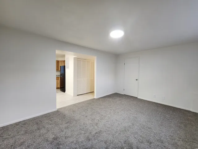 Empty room featuring light colored carpet and baseboards