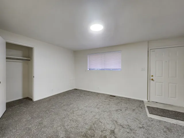 Typical bedroom with light colored carpet and a closet