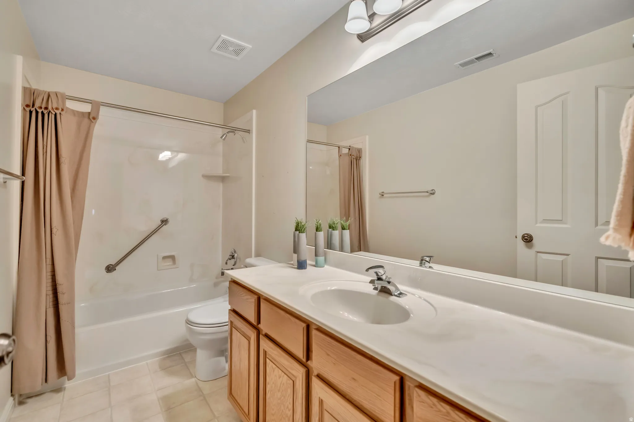 Bathroom featuring vanity and shower / bath combination with curtain