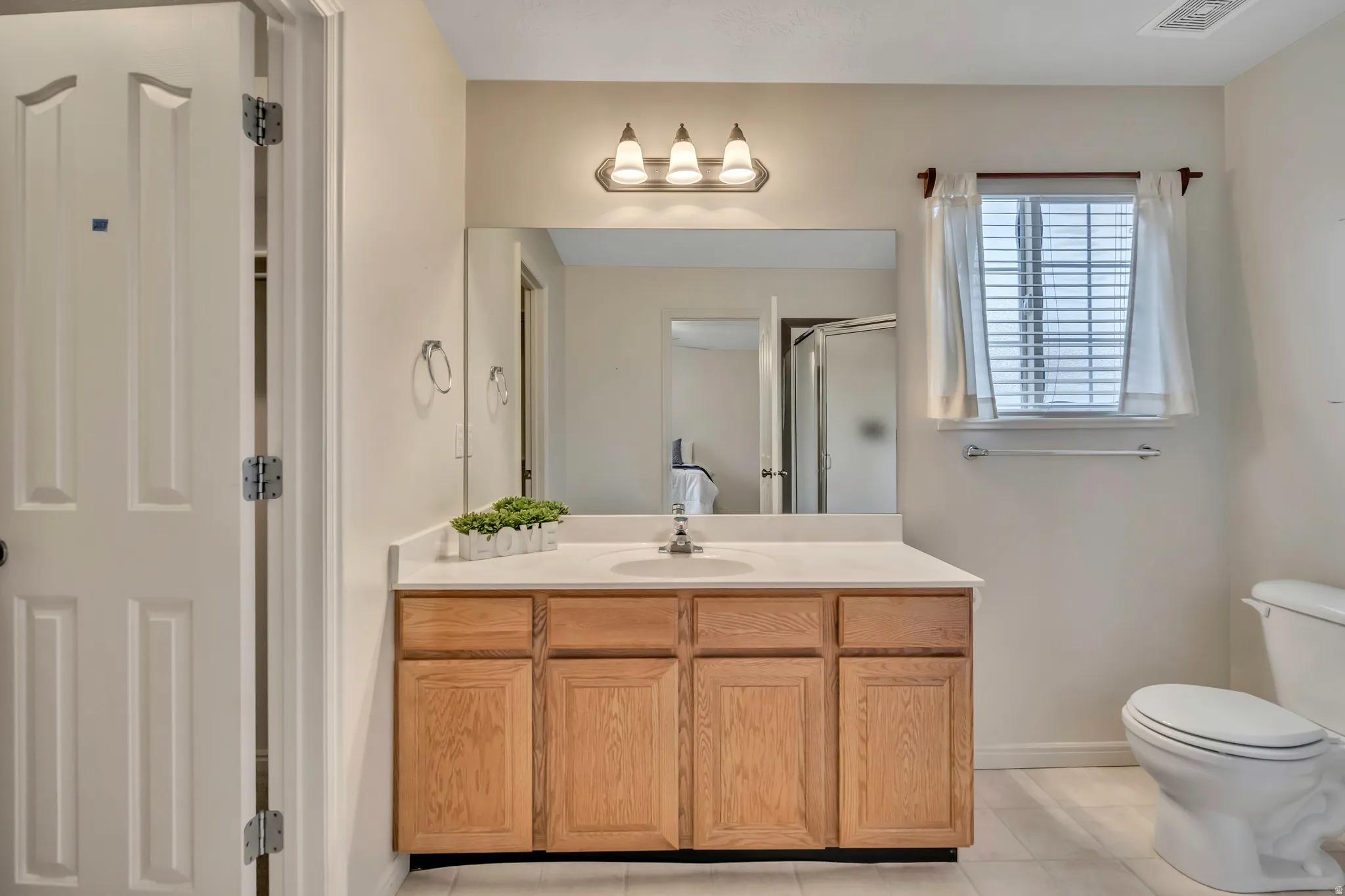 Bathroom with vanity, a stall shower, and light tile patterned floors