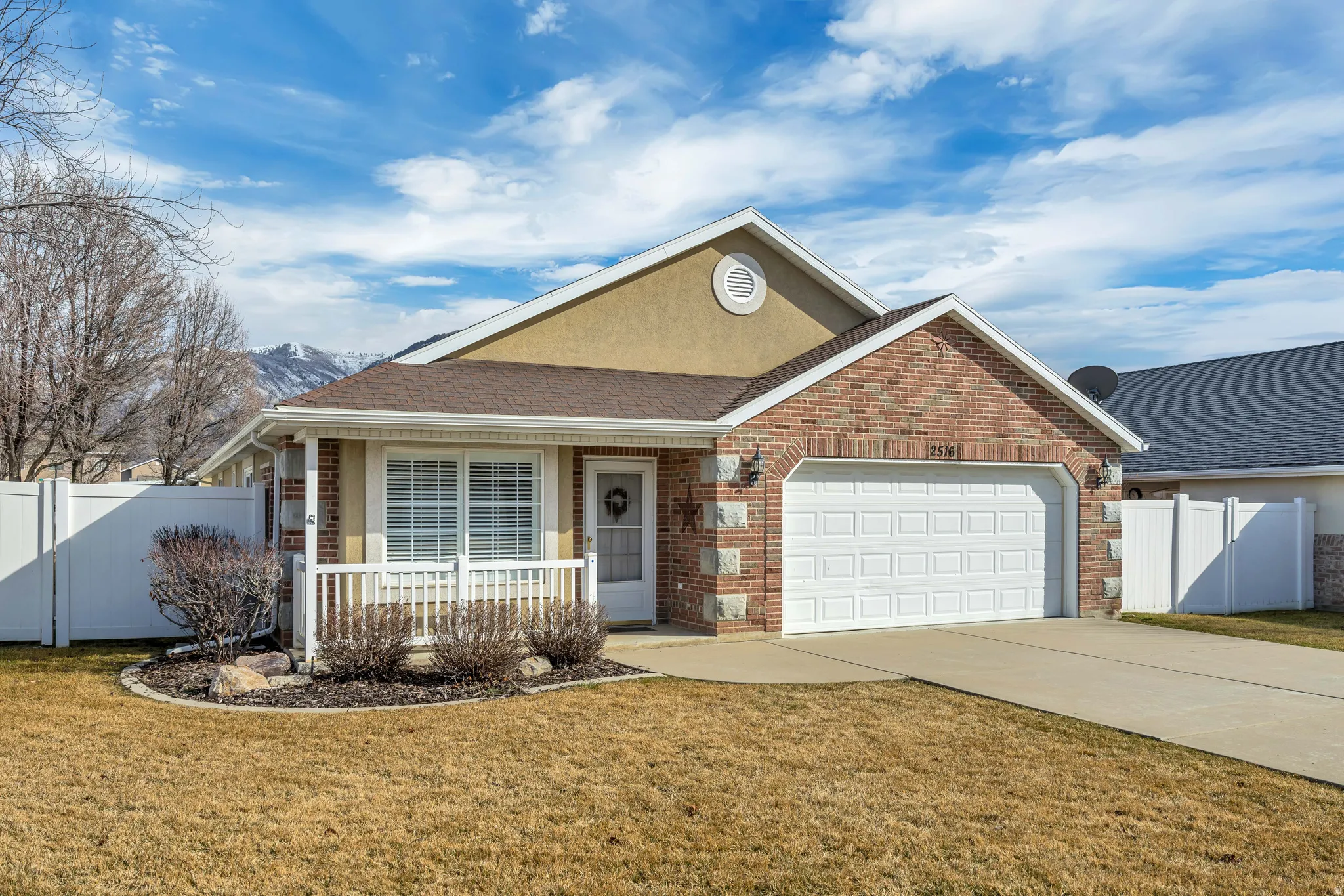 Ranch-style house with roof with shingles, brick siding, an attached garage, and concrete driveway