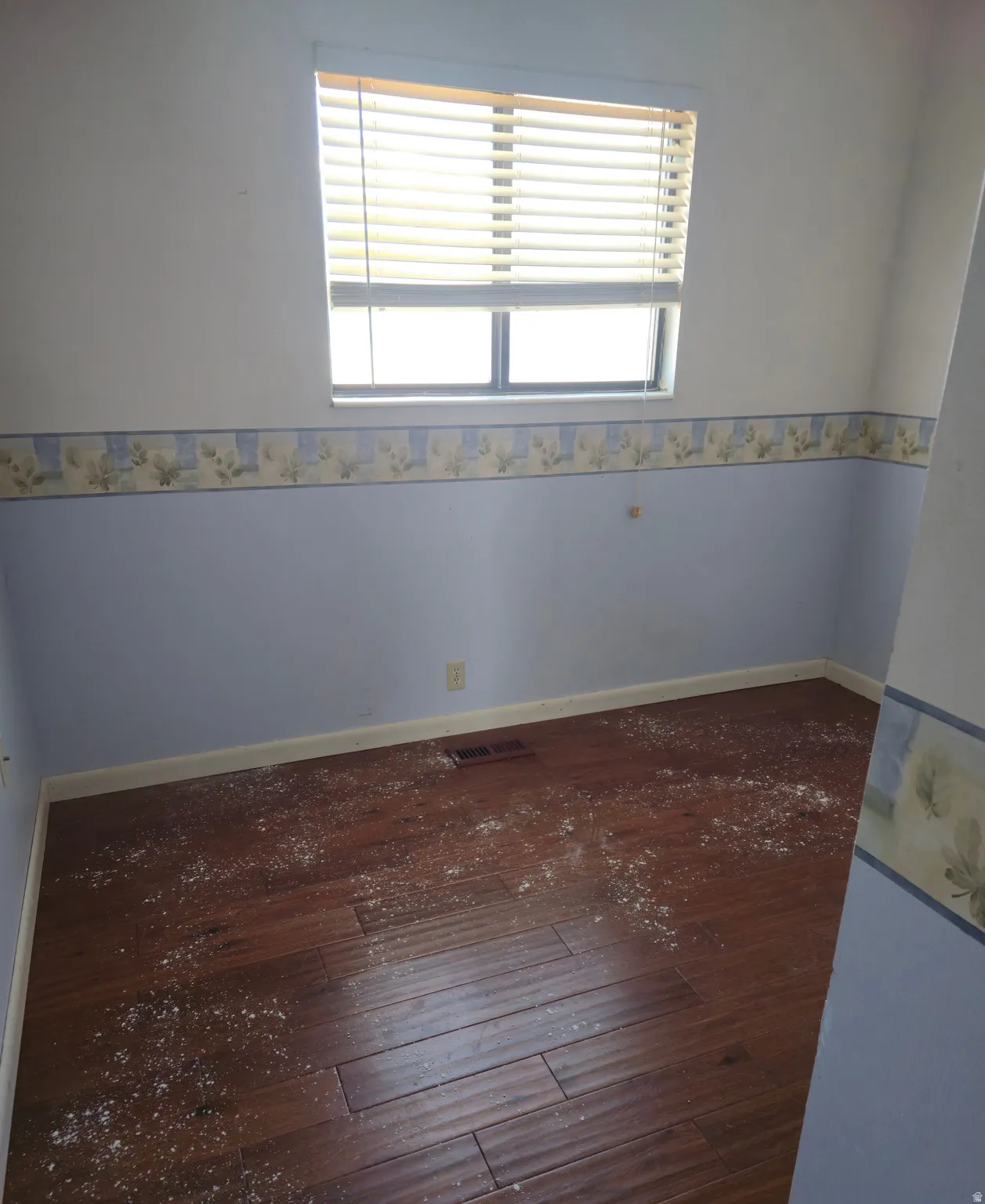 Empty room featuring dark wood-style flooring and baseboards