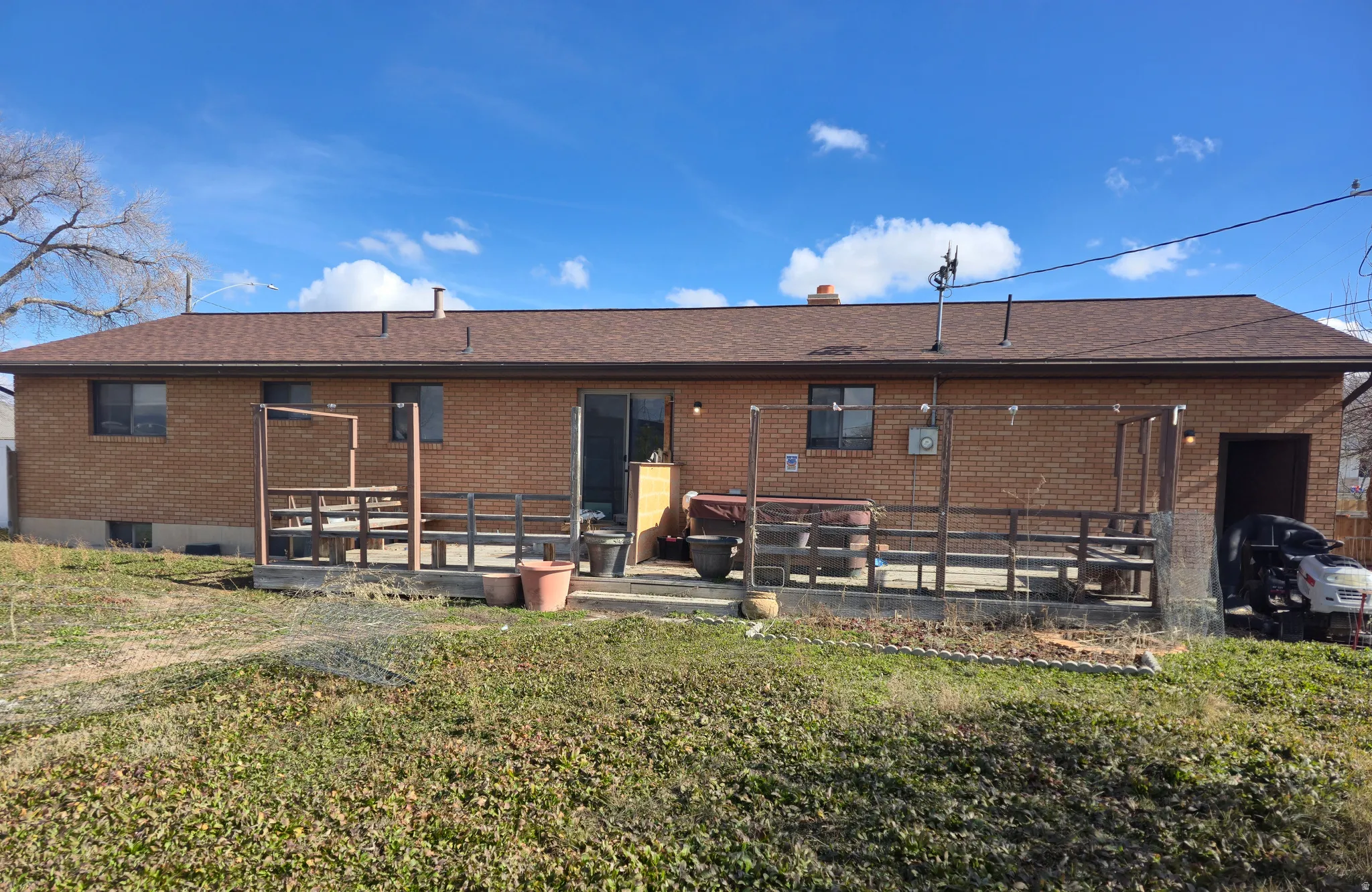 Back of house with brick siding, a yard, and a chimney