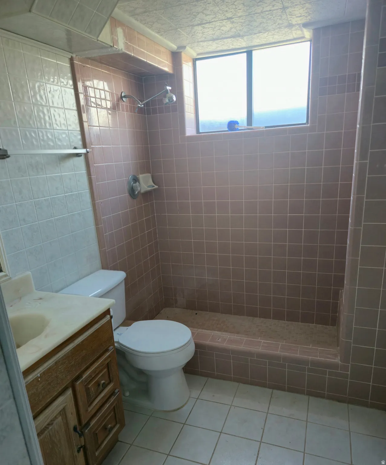 Bathroom featuring a shower stall, vanity, and light tile patterned floors