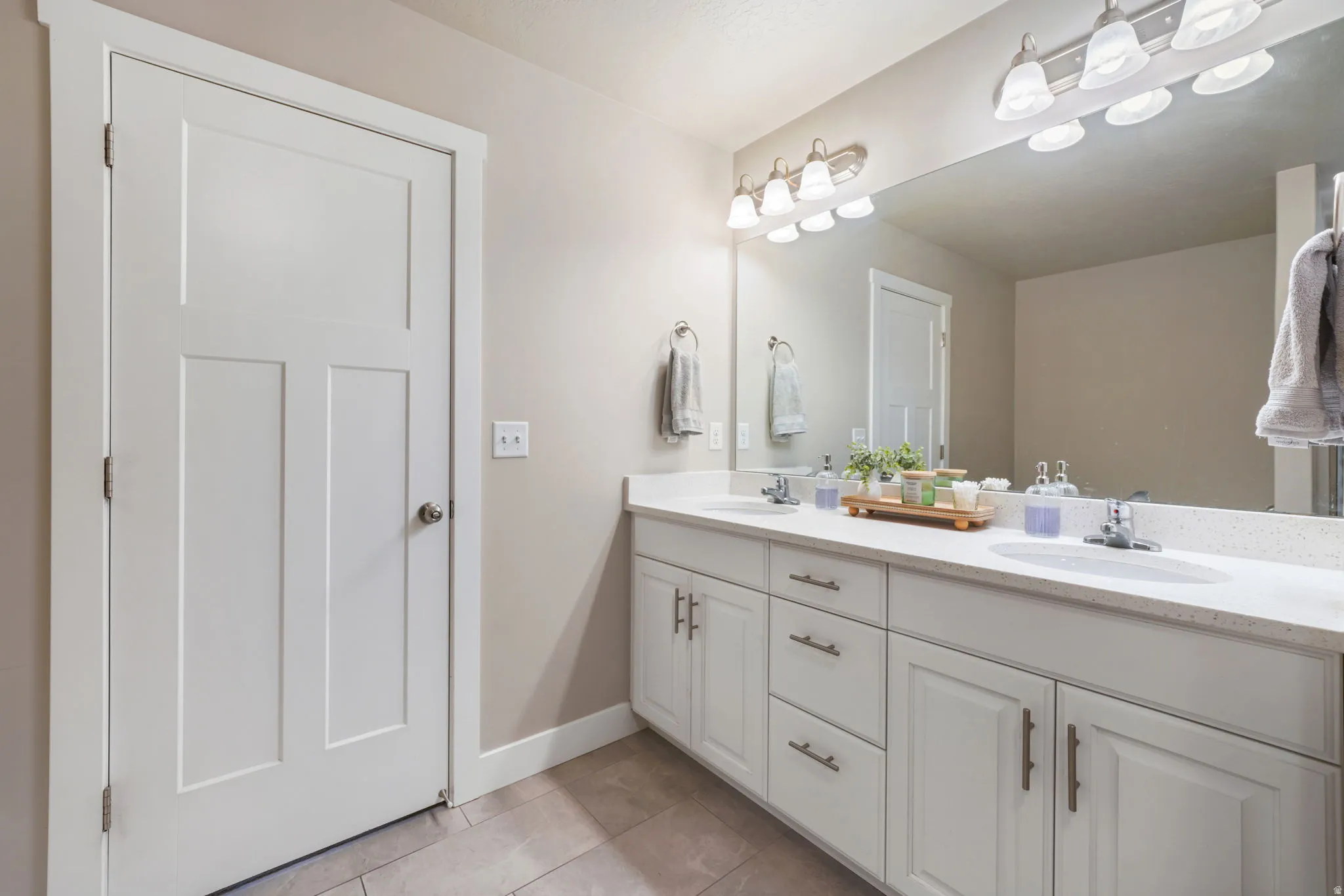 Bathroom featuring double vanity and light tile patterned floors