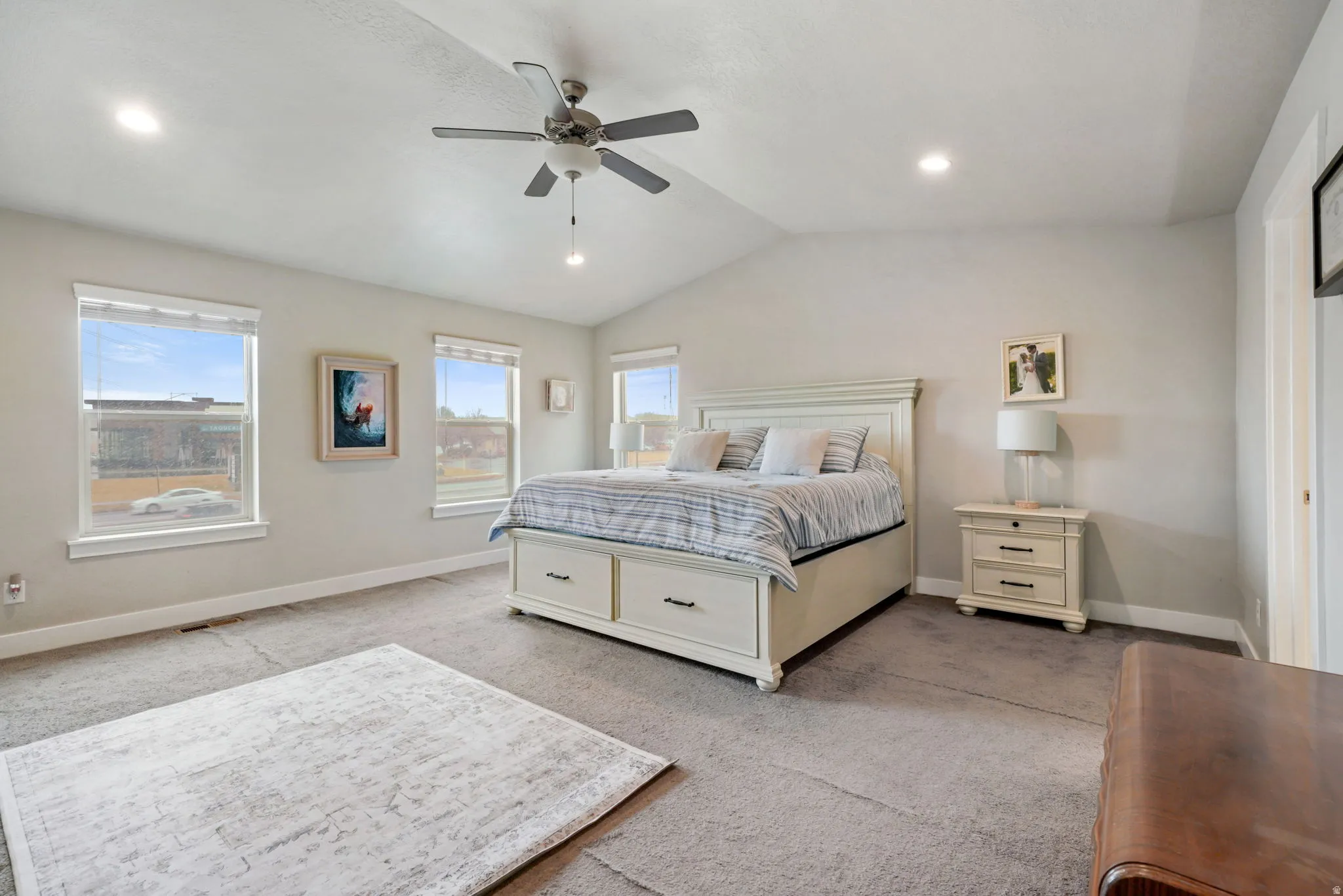 Bedroom with carpet floors, a ceiling fan, and multiple windows