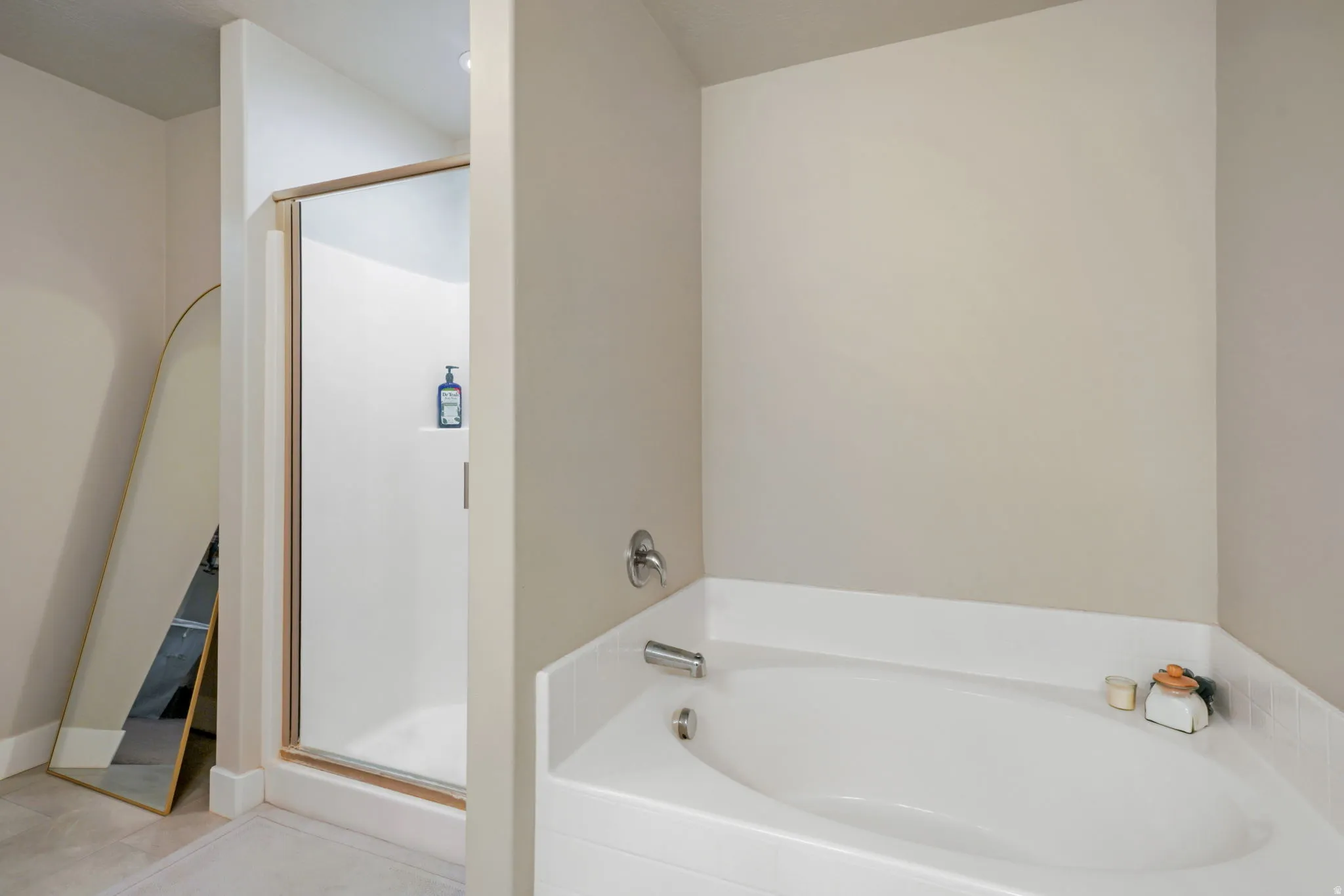 Bathroom featuring a bath, a stall shower, and light tile patterned floors