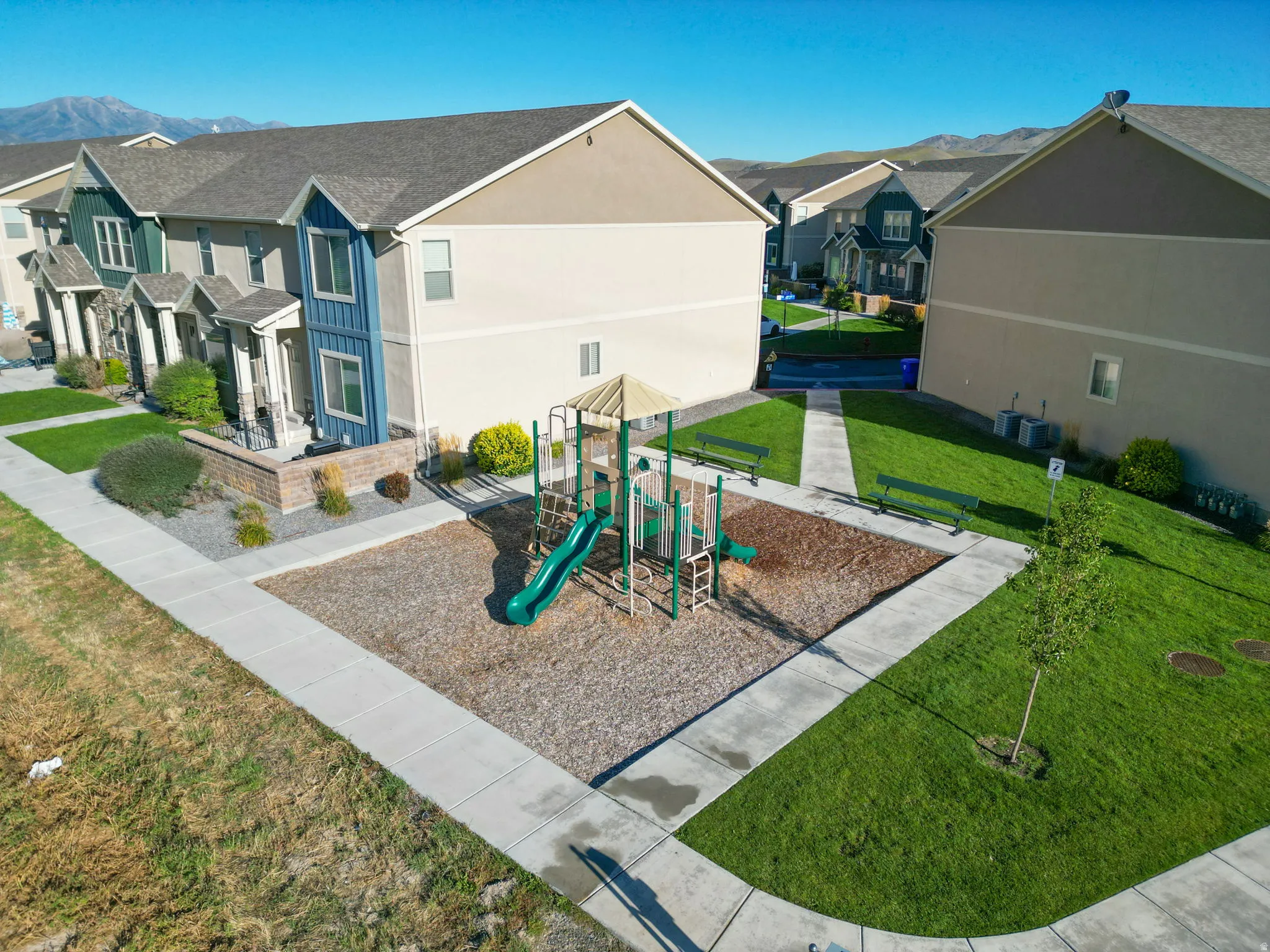 Community jungle gym with a yard, a residential view, and a mountain view