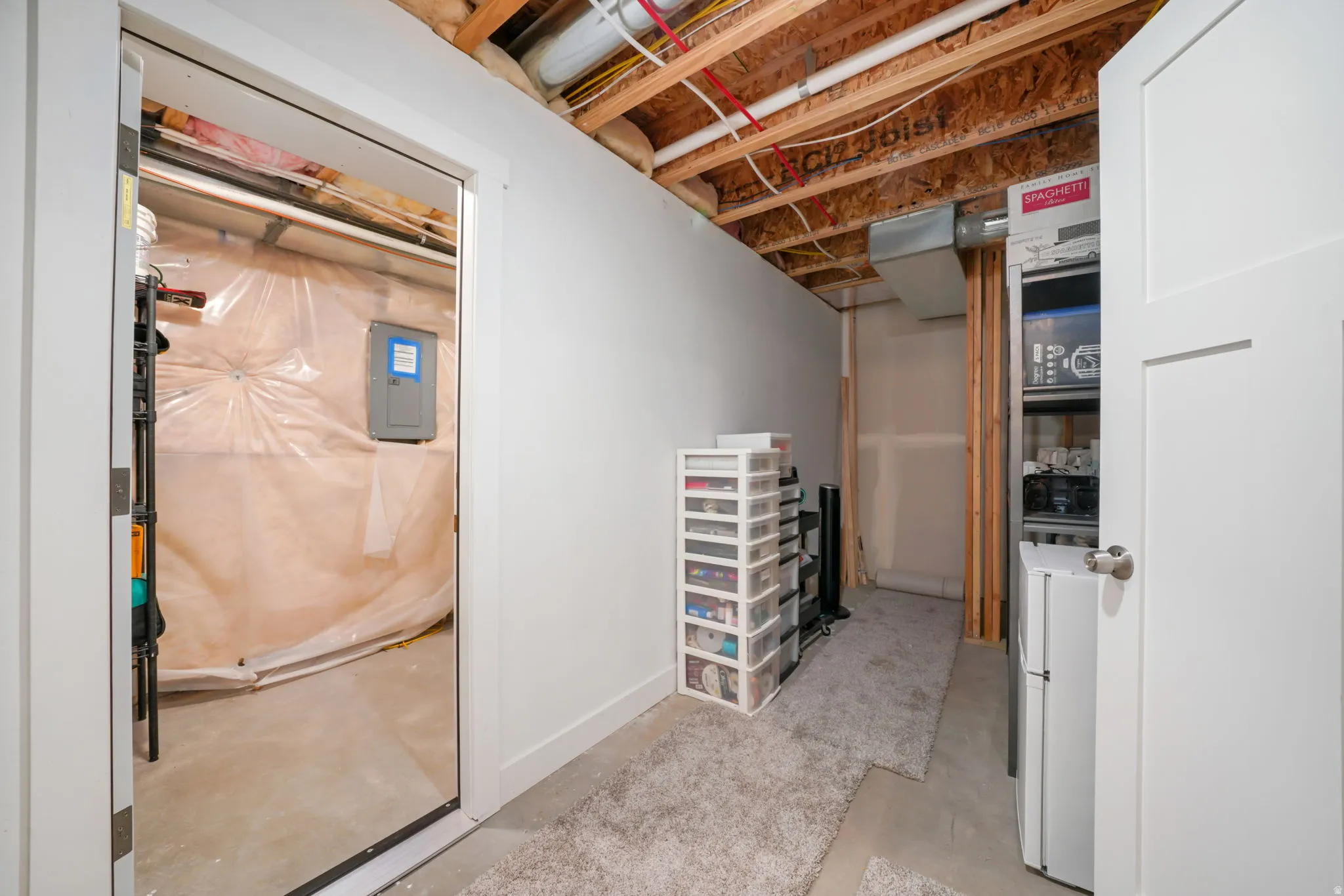 Unfinished basement featuring washer / dryer and electric panel