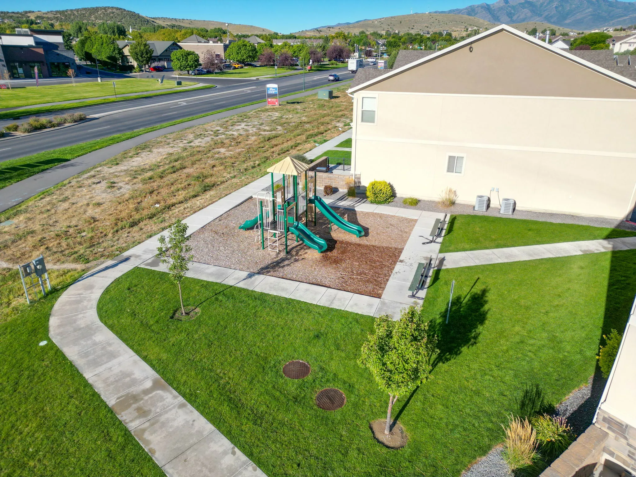 Community jungle gym featuring a lawn, a mountain view, and a patio