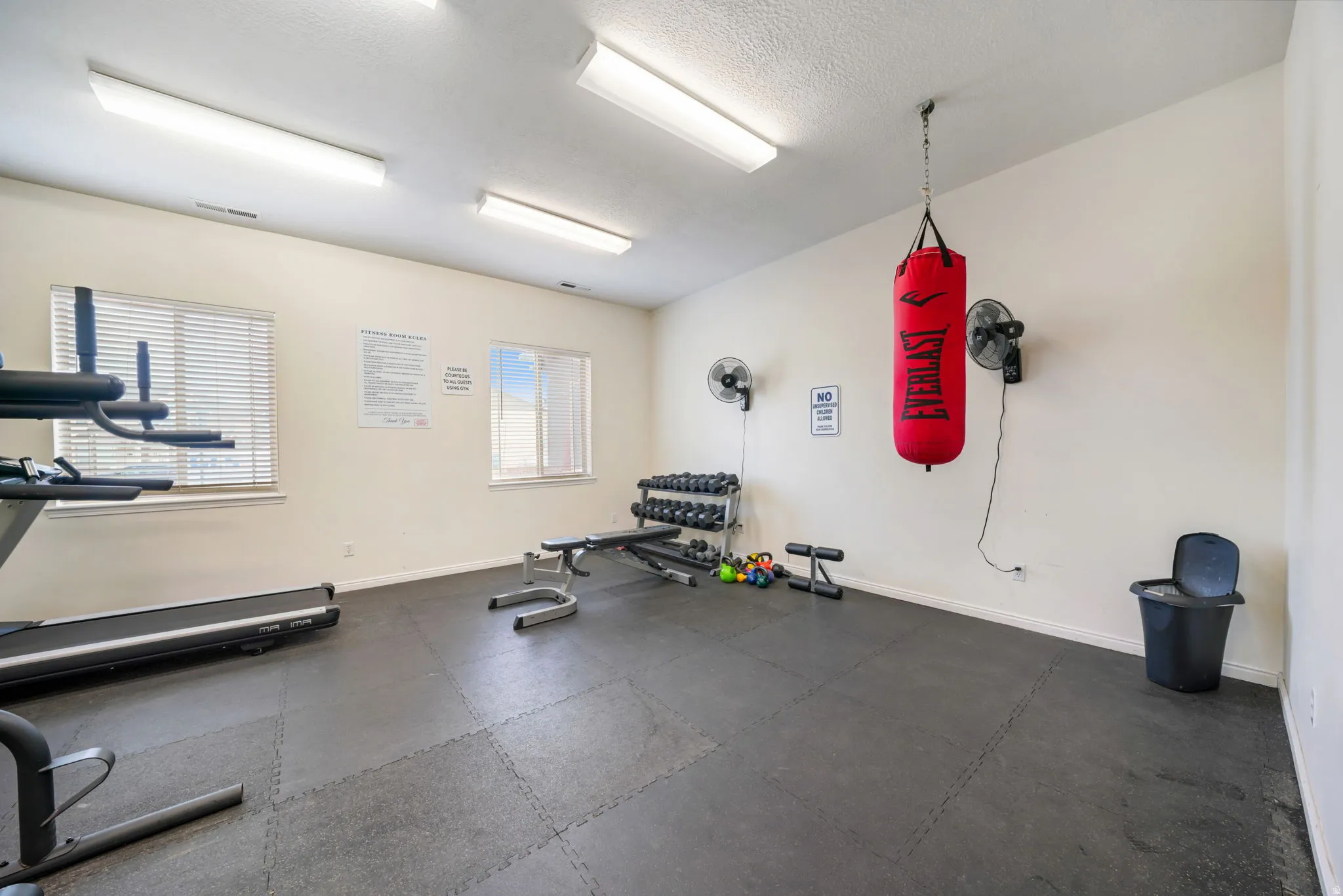 Exercise room with dark flooring and baseboards