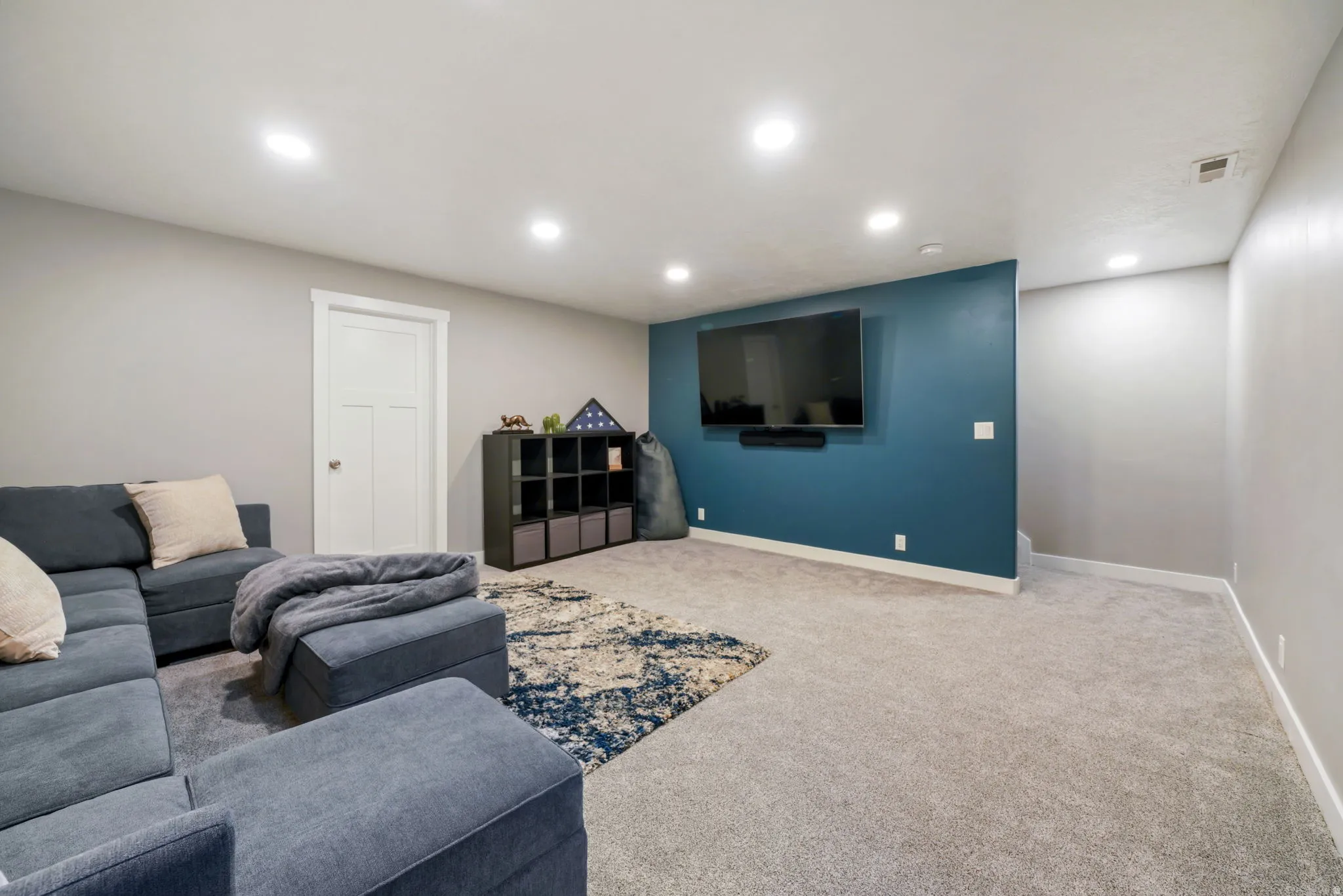 Carpeted living area featuring recessed lighting and baseboards
