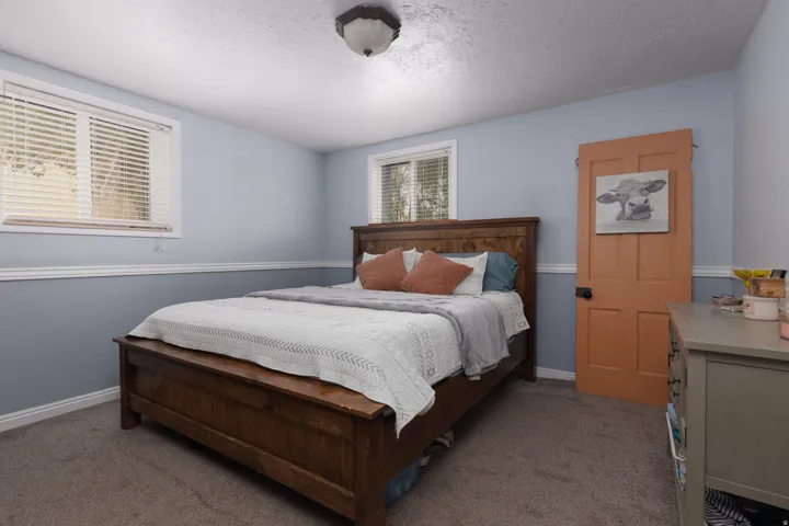 Carpeted bedroom with a textured ceiling and baseboards