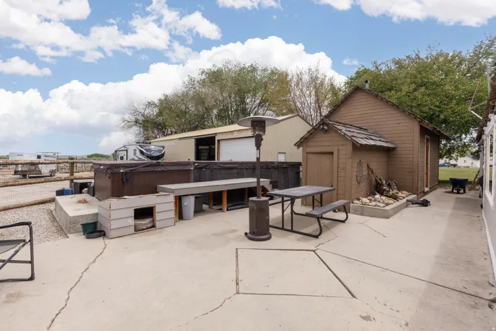 View of patio / terrace featuring a hot tub, an outdoor structure, and outdoor dining area
