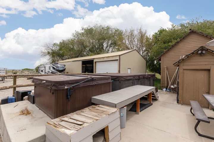 View of patio / terrace featuring a hot tub and a shed