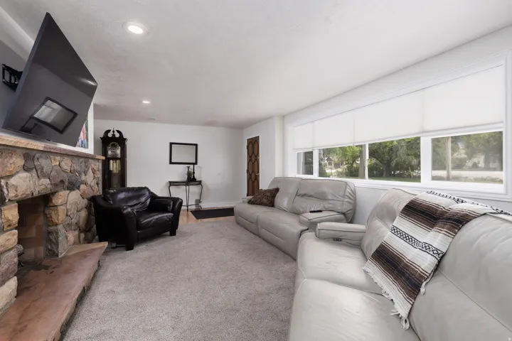 Living area with a fireplace, carpet flooring, and recessed lighting