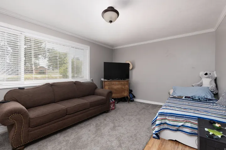 Bedroom featuring crown molding and wood finished floors