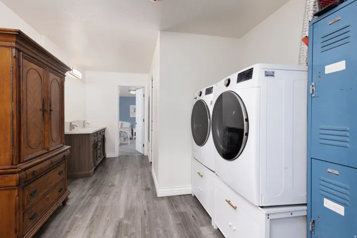 Laundry area with light wood-style flooring and washing machine and clothes dryer