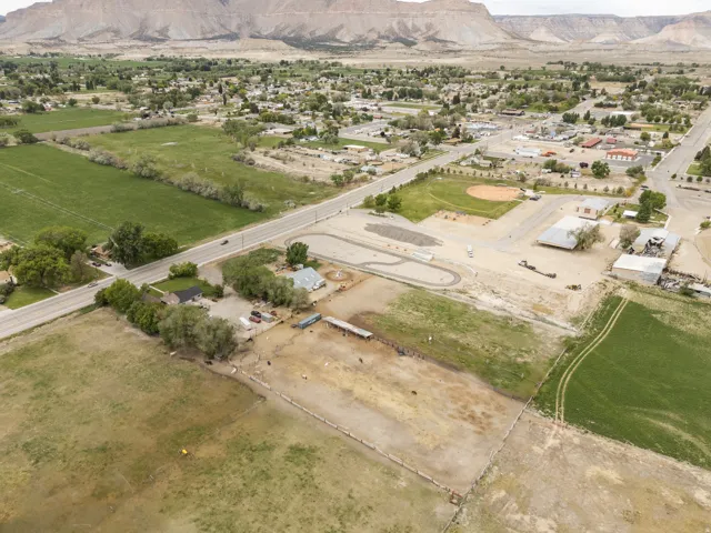Aerial view of property and surrounding area featuring a mountainous background and rural landscape