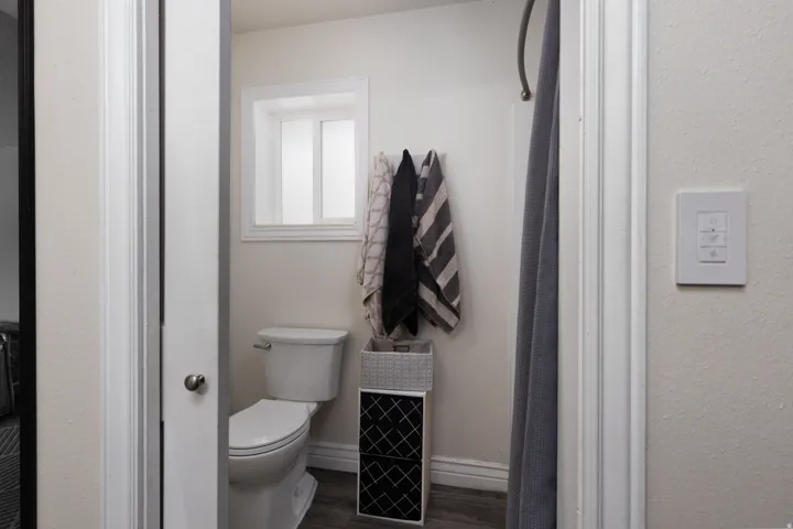 Bathroom featuring baseboards and dark wood finished floors