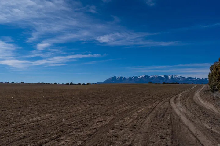 View of dirt / gravel road featuring a rural view and a mountain view