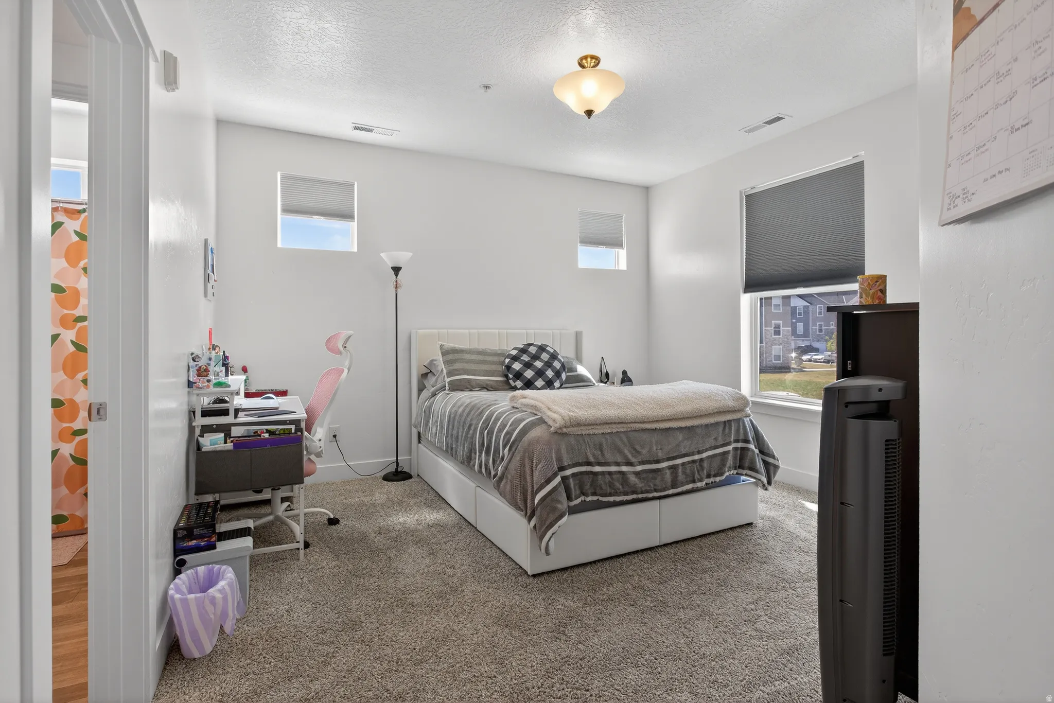 Primary bedroom featuring an office area and a textured ceiling