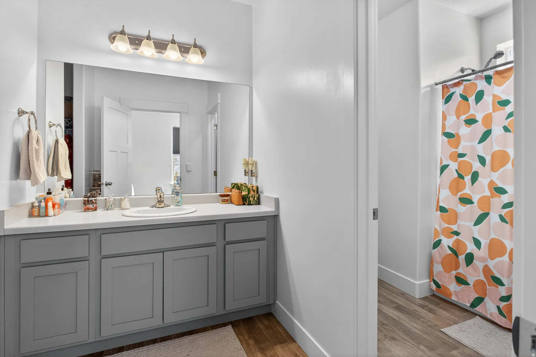 Full bathroom with vanity, a shower with shower curtain, and wood finished floors