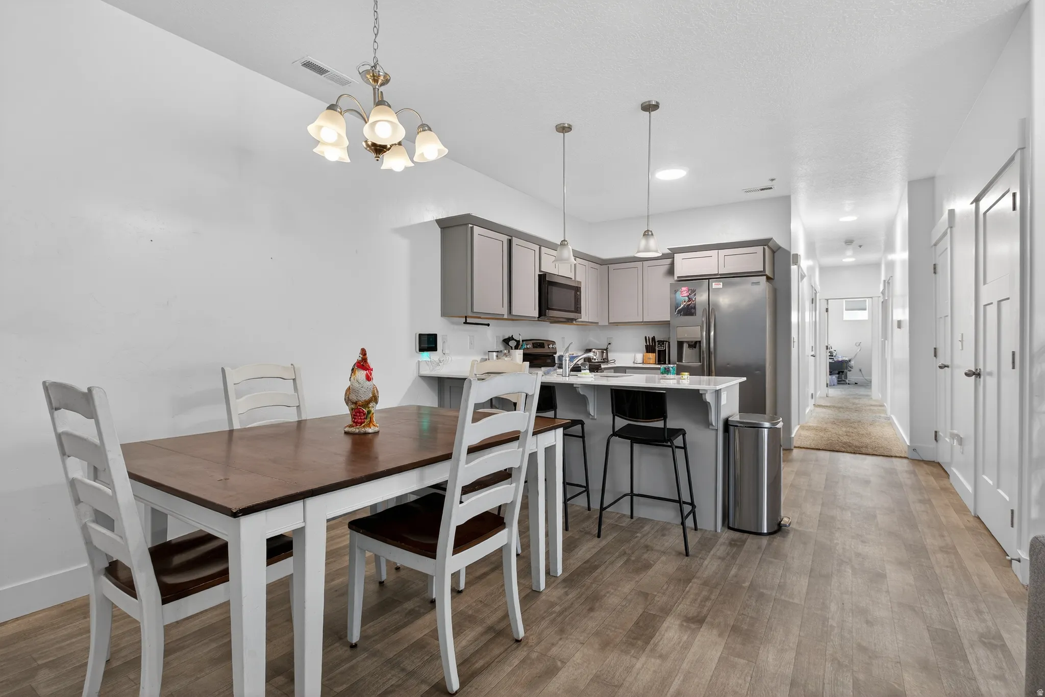 Dining area with light wood-type flooring and suspended lighting