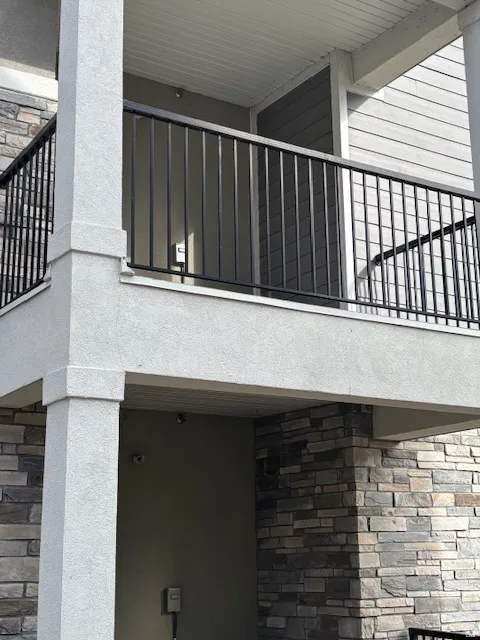 View of side of property with stone siding and a balcony