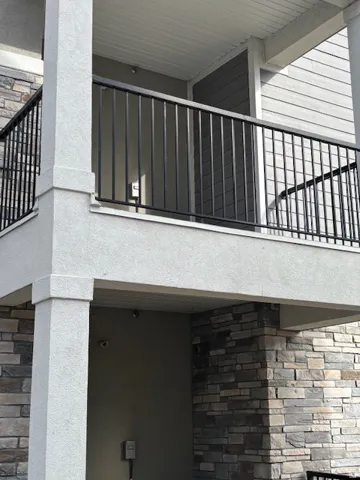 View of side of property with stone siding and a balcony