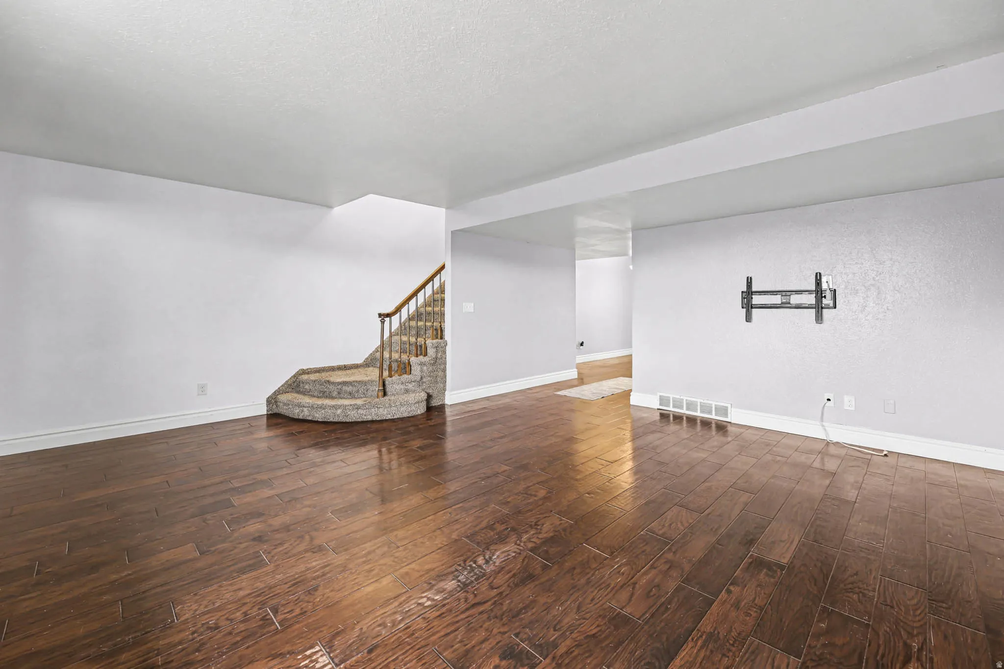 Finished basement with stairway and dark wood-style floors
