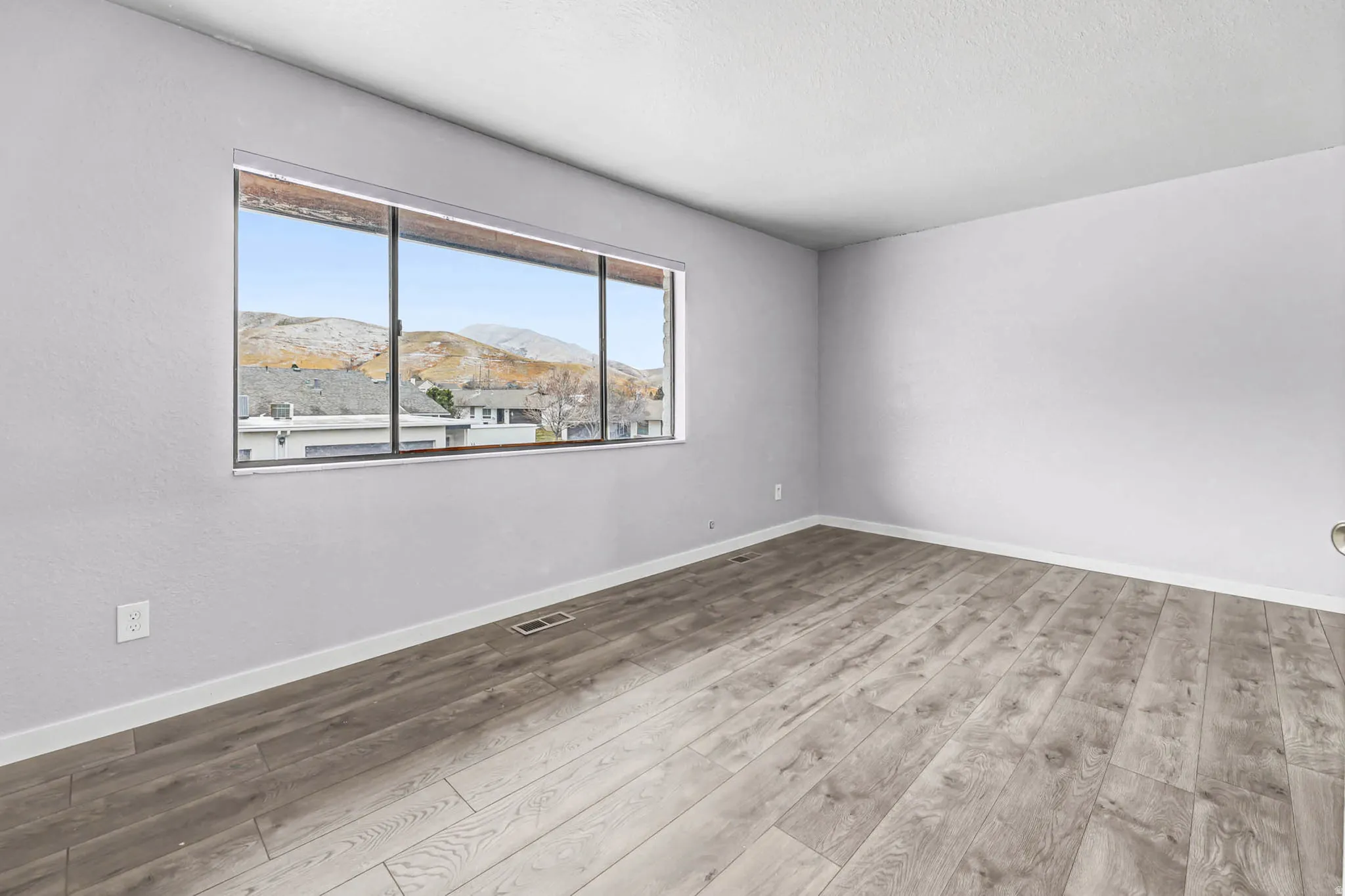 Unfurnished room featuring light wood-style flooring and a mountain view