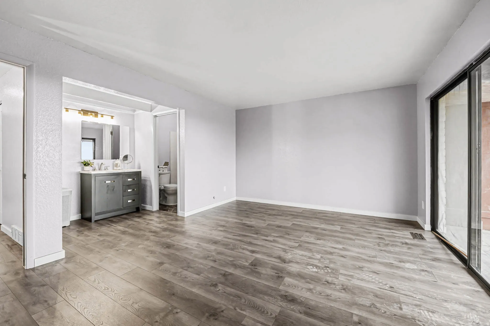 Unfurnished bedroom with access to exterior and wood finished floors