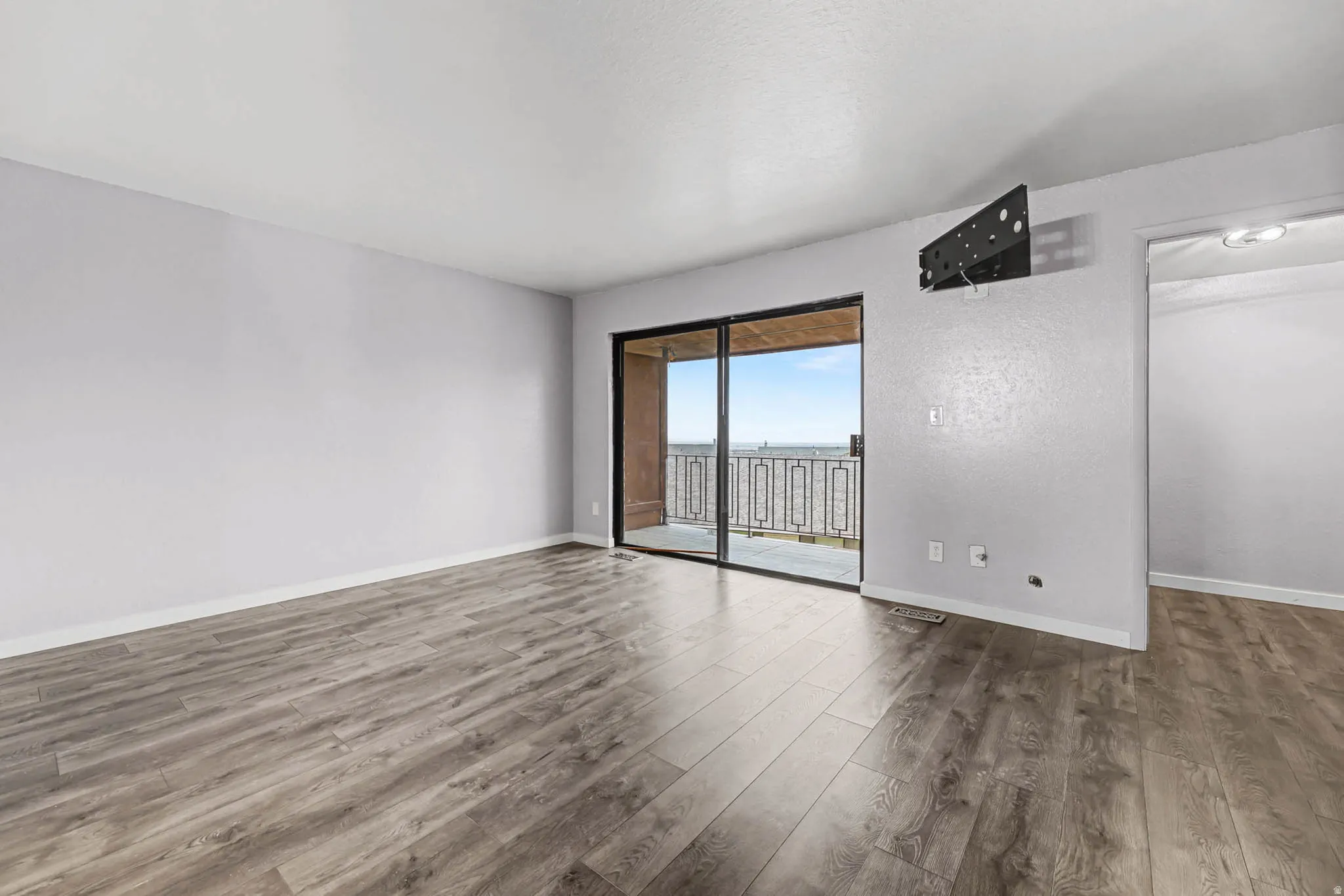 Unfurnished room with wood finished floors and baseboards