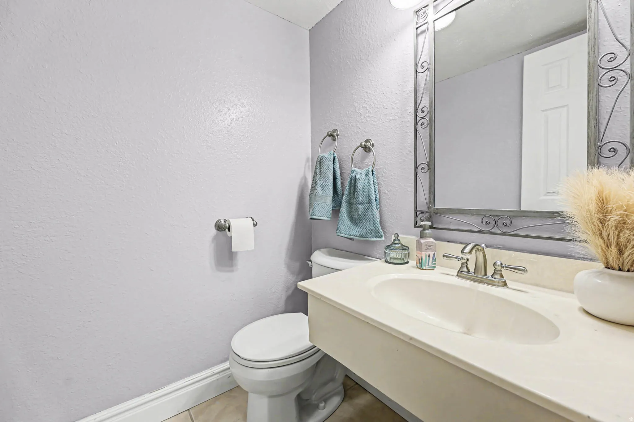 Half bathroom featuring a textured wall and vanity
