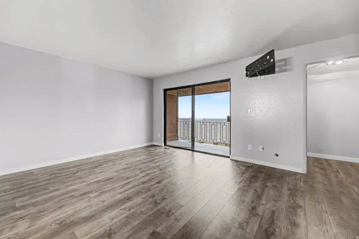Unfurnished room with wood finished floors and baseboards