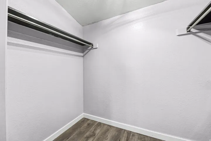 Walk in closet featuring dark wood-style flooring
