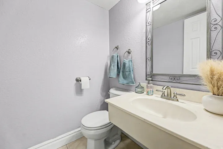 Half bathroom featuring a textured wall and vanity