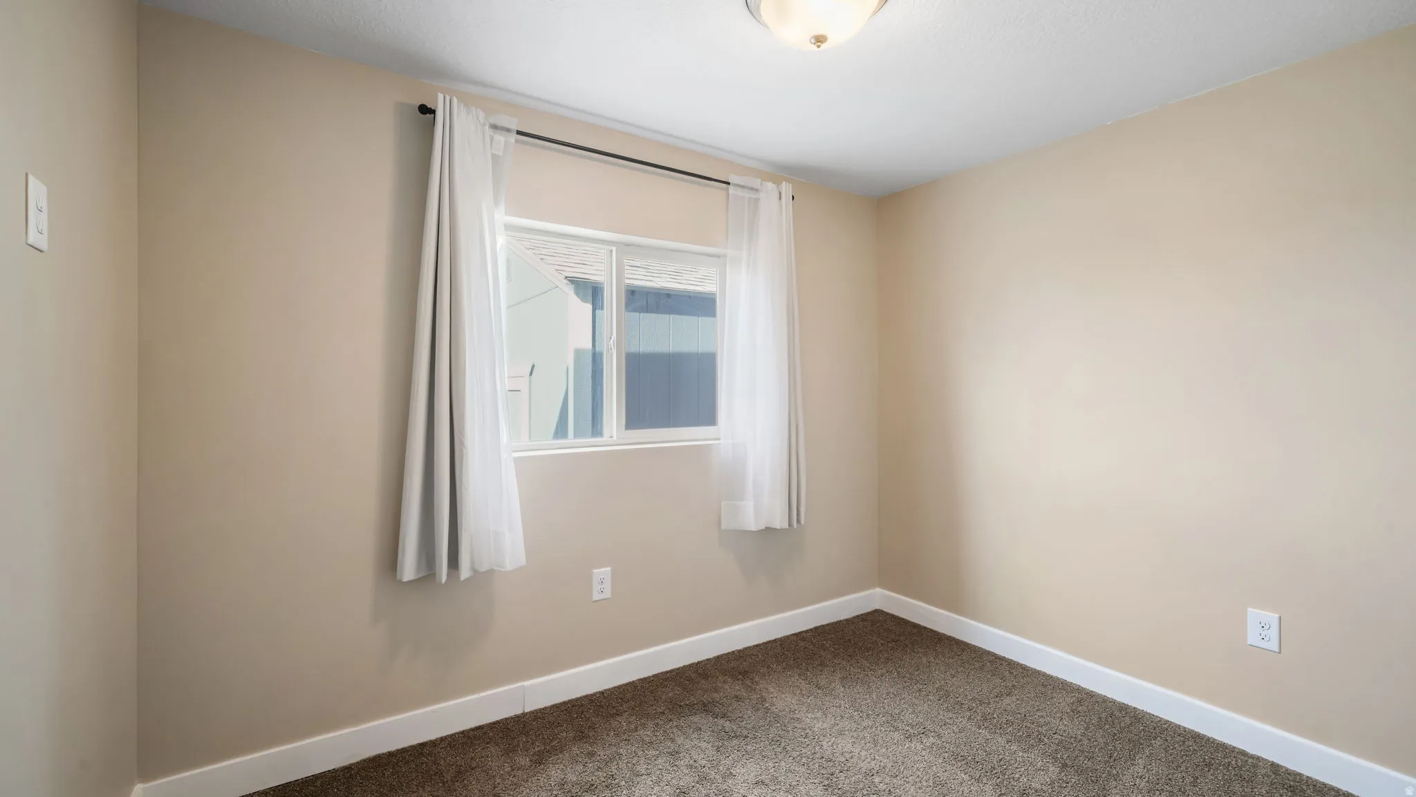 Carpeted empty room with baseboards