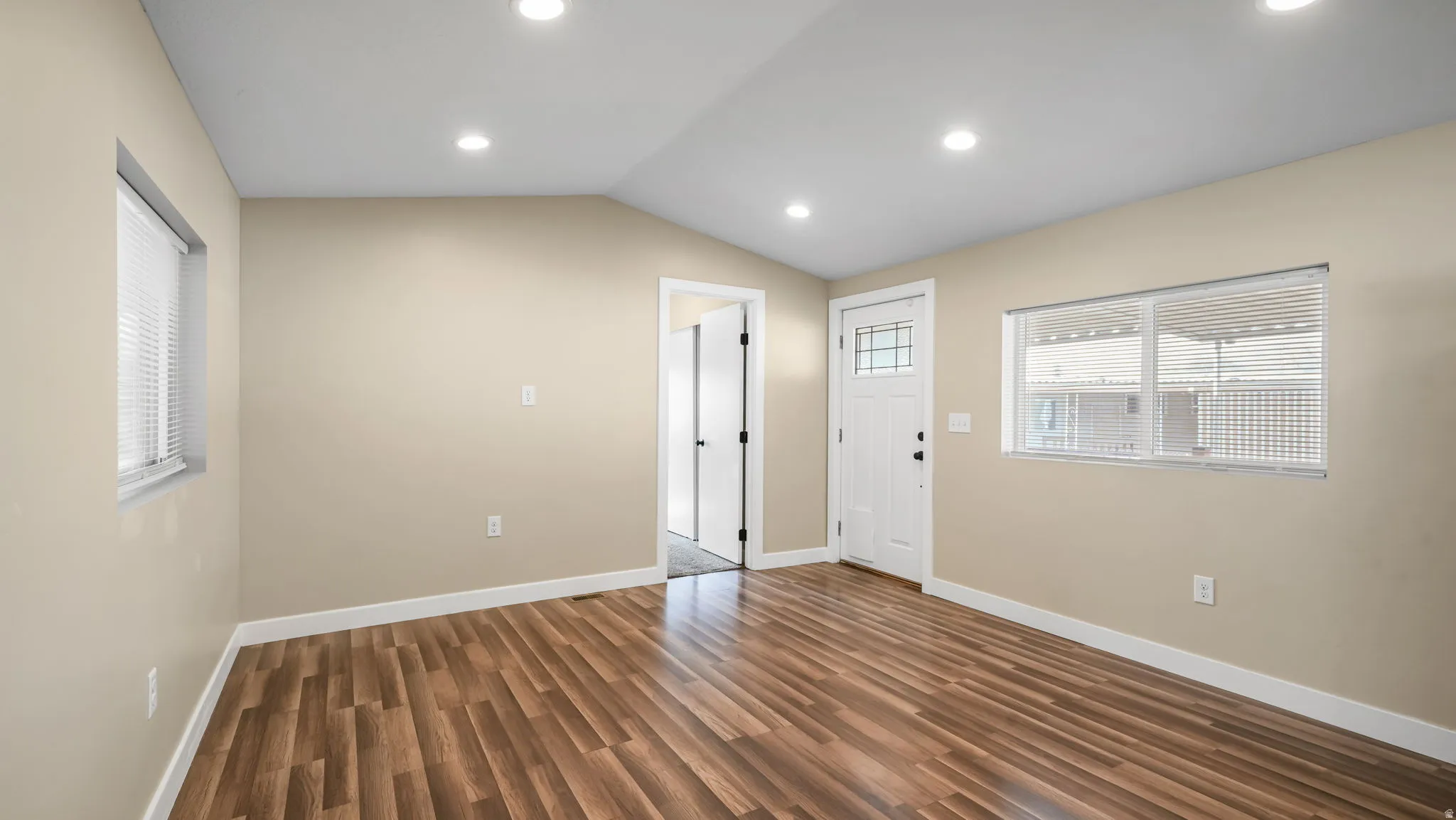 Foyer entrance featuring vaulted ceiling, dark wood finished floors, and recessed lighting